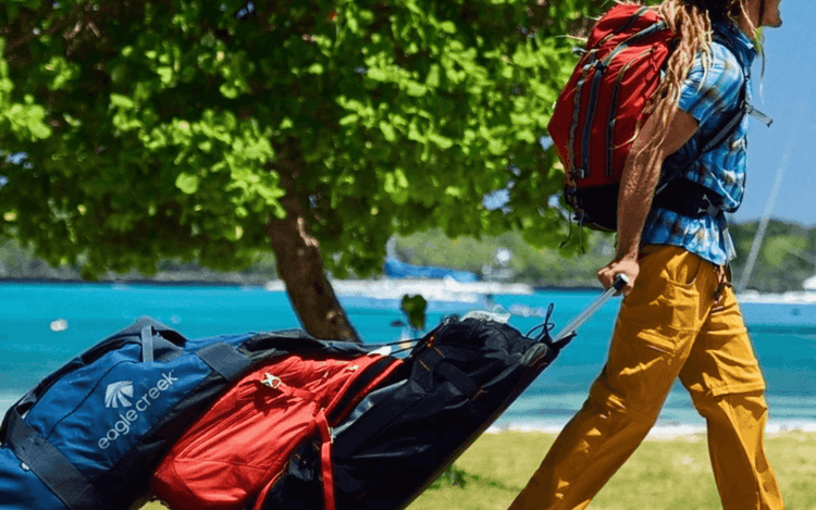 Traveler pulling adventure bags along a beach, ready for exploration - Adventure Travel Luggage - Adventure Gear from Global Trekker