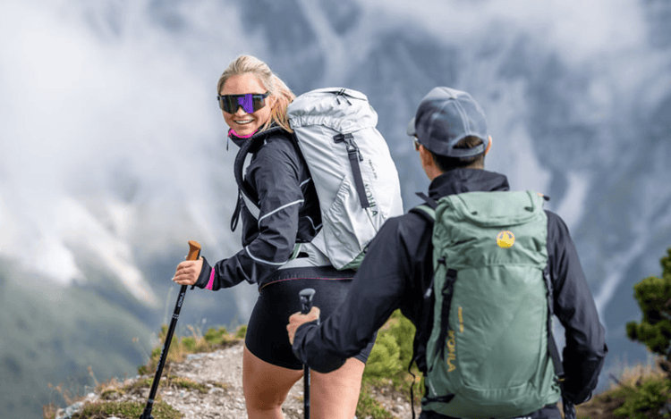 Hikers enjoying the outdoors, showcasing durable backpacks on a mountain trail. Backpacks - Adventure Gear From Global Trekker.