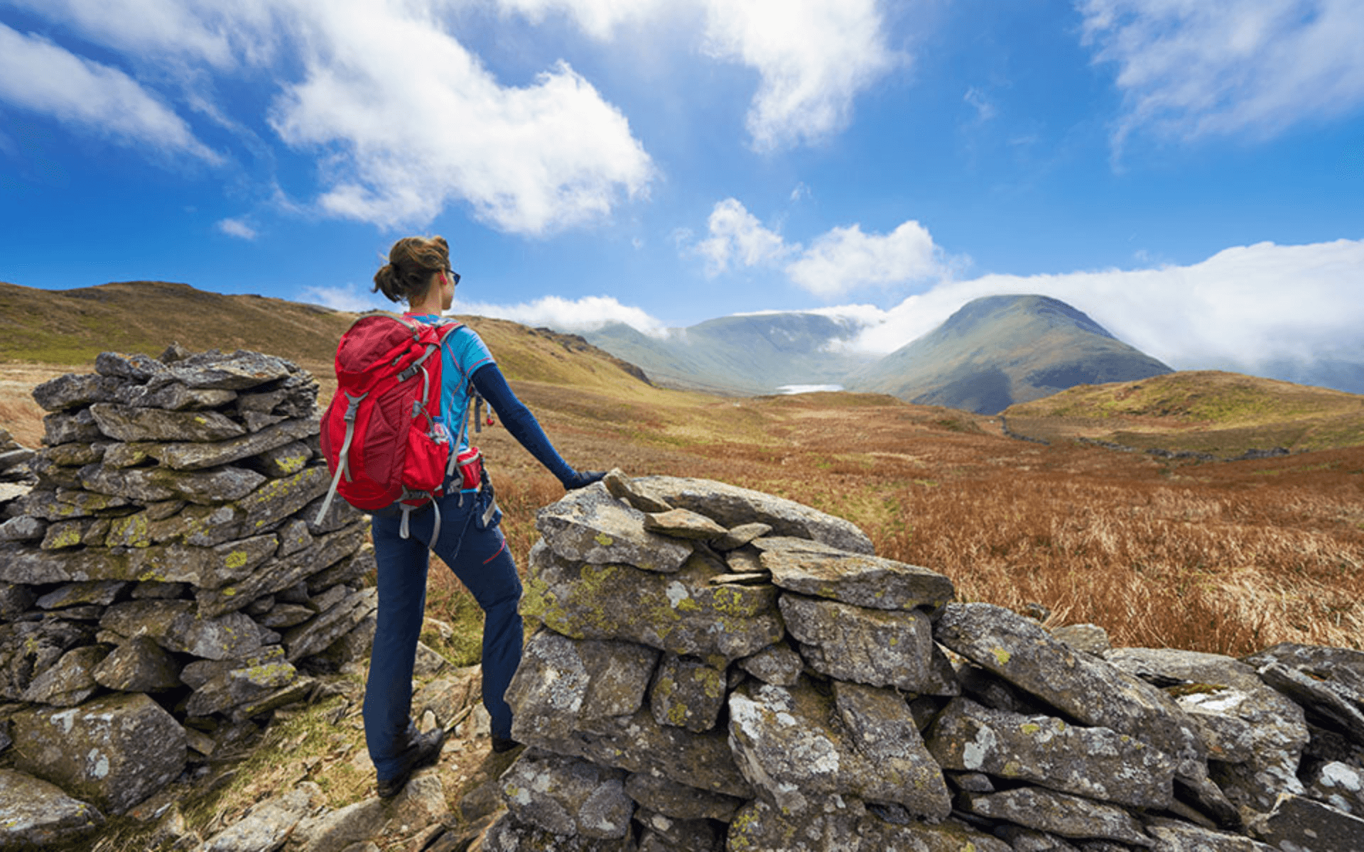 Woman hiker overlooking scenic mountains and valleys, showcasing outdoor adventure opportunities. Adventure Gear By Global Trekker.